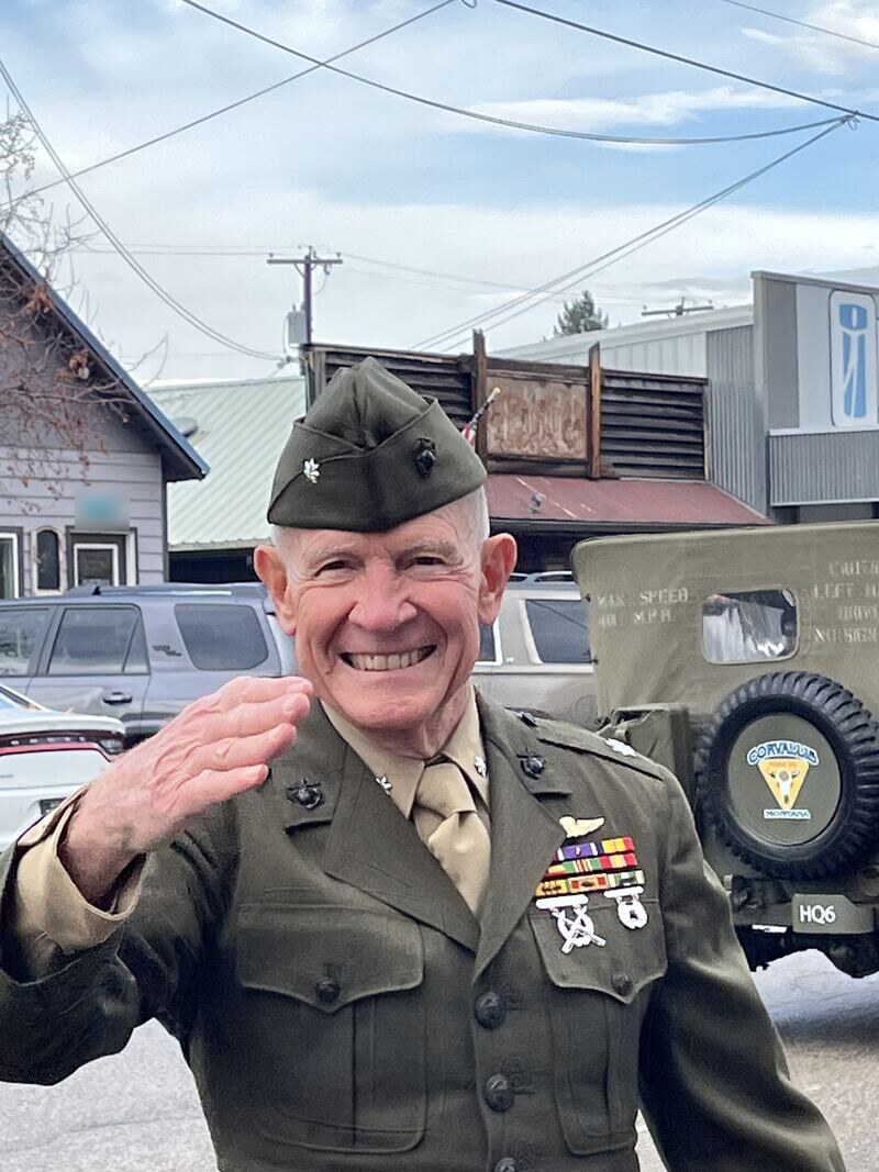 Harris Himes in Marine Corps dress greens and garrison cap, smiling and saluting beside a restored military jeep
